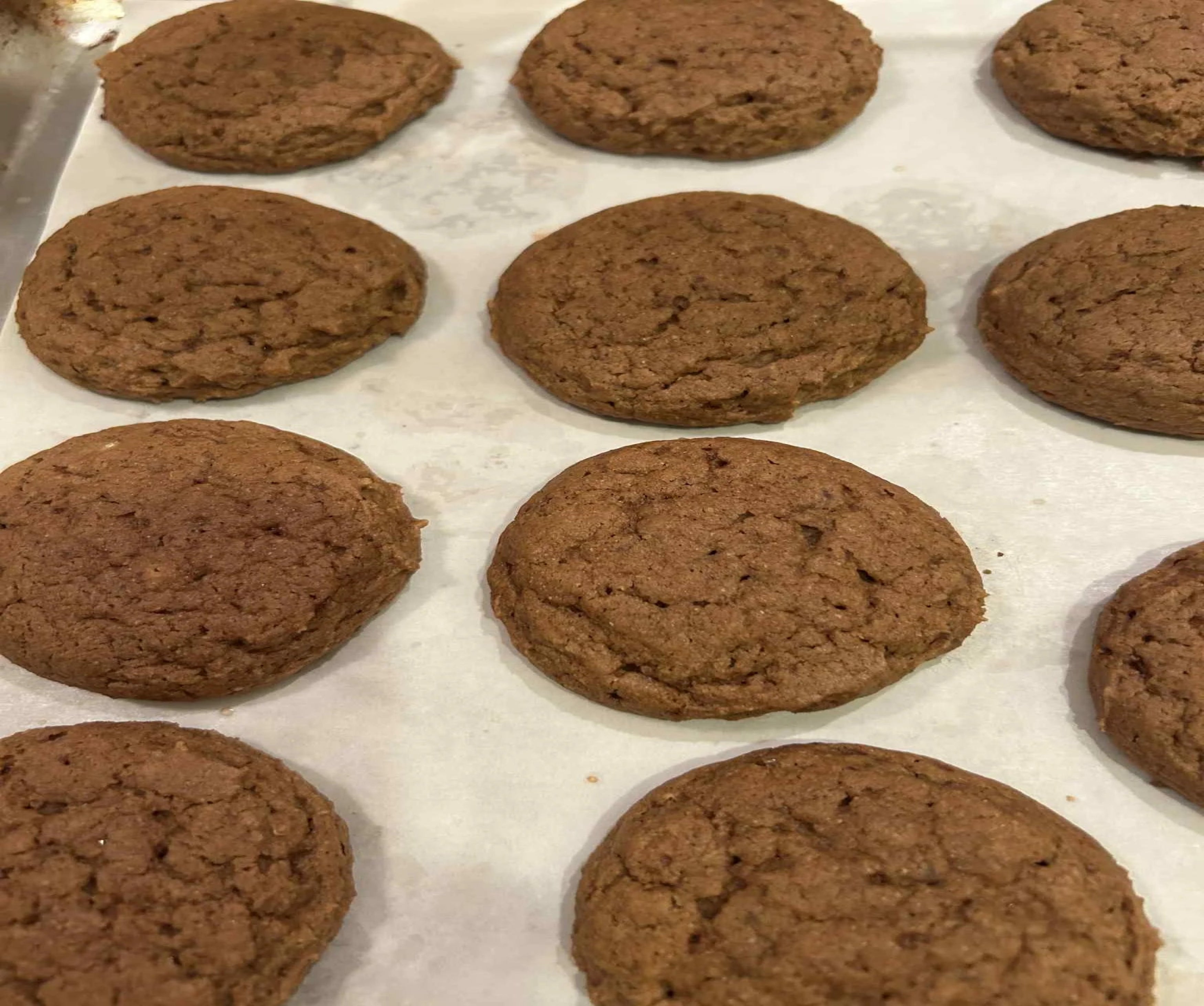 Freshly baked pumpkin spice cookies on a baking sheet.