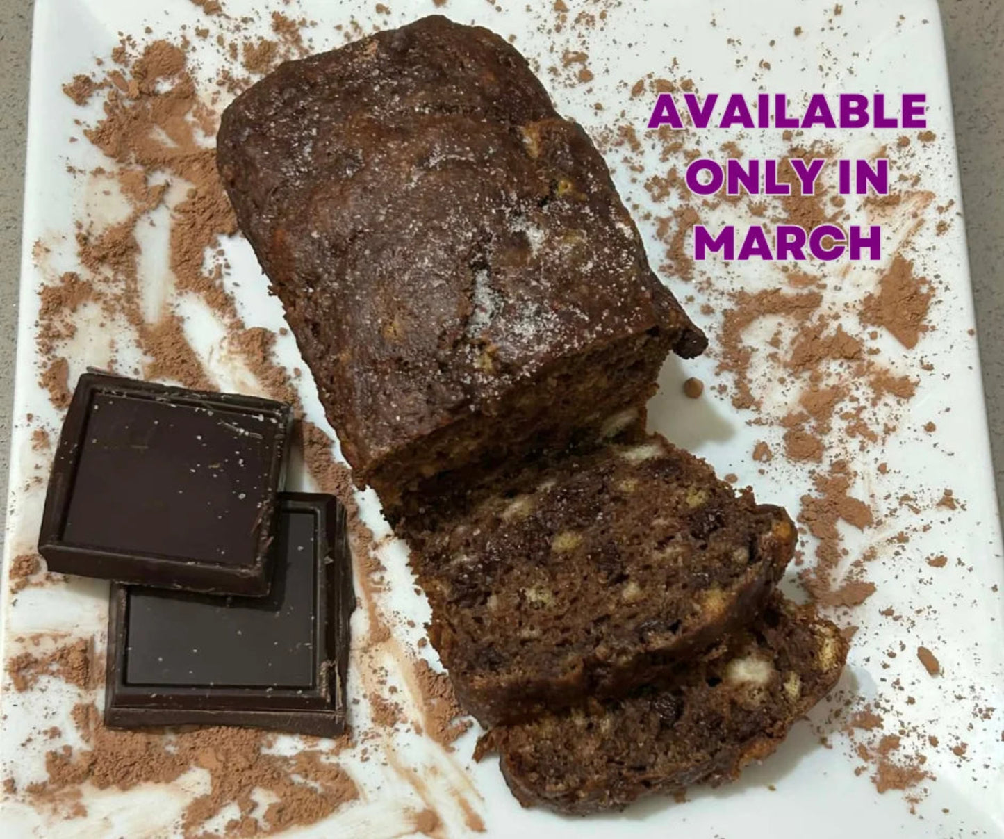 Chocolate loaf cake with slices on a white surface, surrounded by chocolate pieces, with text 'AVAILABLE ONLY IN MARCH' in purple.